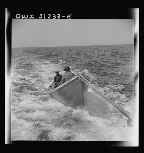 On board the fishing boat Alden, out of Gloucester, Massachusetts. A dory with men, being towed during a mackerel chase