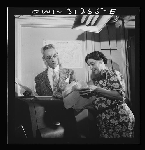 Washington, D.C. Preparing an advisory forecast at the U.S. Weather Bureau. Weather observational reports are received by teletype system from all parts of the country at a forecast center for plotting on manuscript sectional maps. Mr. Jean Gallene examining a report that has just been received