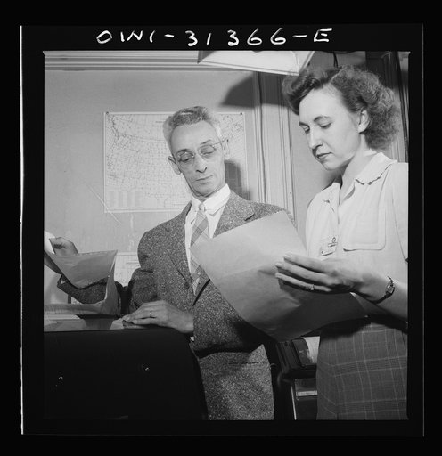 Washington, D.C. Preparing an advisory forecast at the U.S. Weather Bureau. Weather observational reports are received by teletype system from all parts of the country at a forecast center for plotting on manuscript sectional maps. Mr. Jean Gallene examining a report that has just been received