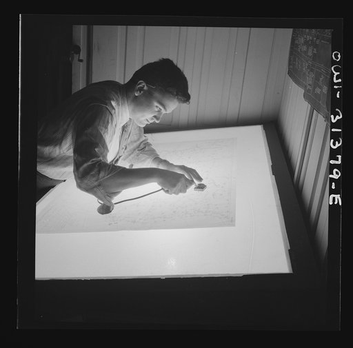 Washington, D.C. Preparing an advisory forecast at the U.S. Weather Bureau. A junior meteorologist assembling plotted sectional weather maps prior to analysis by forecasters