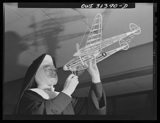 Washington, D.C. Sister Aquinas, "flying nun," applying a little glue to the model P-38 which hangs from the ceiling of her classroom at Catholic University. A veteran of fifteen years' teaching experience, the Sister is giving a summer Civil Aeronautics Authority course for instruction
