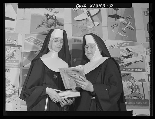 Untitled photo, possibly related to: Washington, D.C. Sister Aquinas, "flying nun," applying a little glue to the model P-38 which hangs from the ceiling of her classroom at Catholic University. A veteran of fifteen years' teaching experience, the Sister is giving a summer Civil Aeronautics Authorit