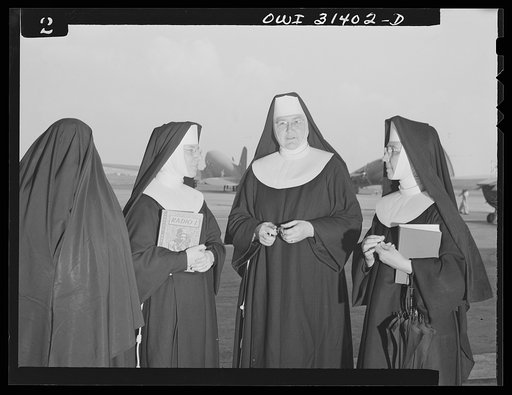 Untitled photo, possibly related to: Washington, D.C. The "flying nun" from Ironwood, Michigan, walking down the field at the Washington National Airport after taking her class through the hangars. Sister Aquinas holds a student pilot's license and has many flying hours to her credit