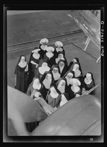 Untitled photo, possibly related to: Washington, D.C. Field trips for the "flying nun" pre-flight class, including inspection tours of hangars at the Washington National Airport. Here, Sister Aquinas is explaining engine structure to her students