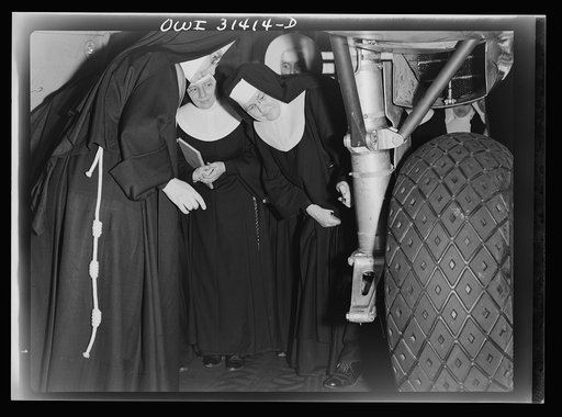 Untitled photo, possibly related to: Washington, D.C. Field trips for the "flying nun" pre-flight class, including inspection tours of hangars at the Washington National Airport. Here, Sister Aquinas is explaining engine structure to her students