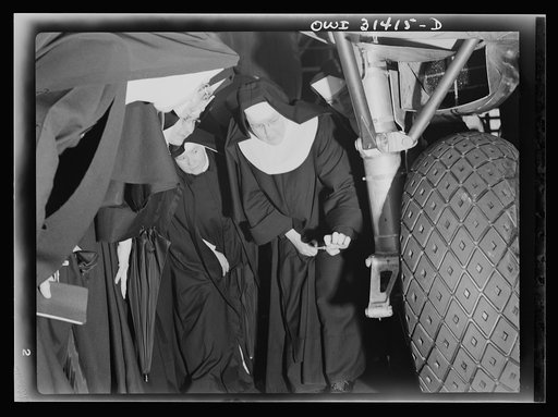 Untitled photo, possibly related to: Washington, D.C. Field trips for the "flying nun" pre-flight class, including inspection tours of hangars at the Washington National Airport. Here, Sister Aquinas is explaining engine structure to her students