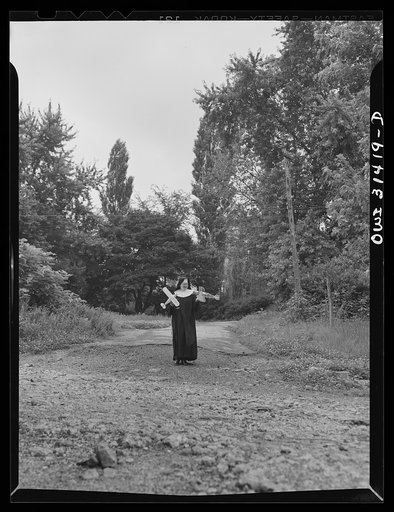 Untitled photo, possibly related to: Washington, D.C. Sister Aquinas, "flying nun", with model planes in hands walking toward the aeronautics laboratory at Catholic University where she gives a daily three-hour preflight Civil Aeronautics Authority course for instructors