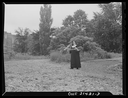 Untitled photo, possibly related to: Washington, D.C. Sister Aquinas, "flying nun", with model planes in hands walking toward the aeronautics laboratory at Catholic University where she gives a daily three-hour preflight Civil Aeronautics Authority course for instructors