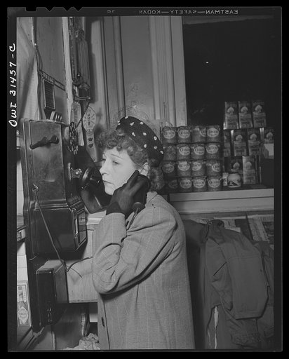 A woman at a telephone in a meat market, a scene from "Black Marketing," a motion picture produced by the U.S. Office of War Information (OWI) and released August 19, 1943