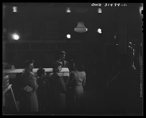 Customers waiting for the butcher in a grocery store, in a scene during the filming of "Black Marketing," a motion picture produced by the U.S. Office of War Information (OWI) and released August 19, 1943