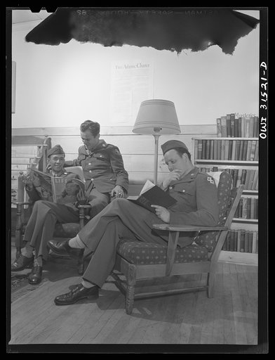 Untitled photo, possibly related to: Oswego, New York. A Chinese in the U.S. Army and two American soldiers reading in the Oswego USO (United Service Organizations) club