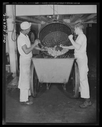 Untitled photo, possibly related to: Cincinnati, Ohio. Preparing canned pork (Russian: "svinaia tushonka") for lend-lease shipment to the USSR at the Kroger grocery and baking company. Removing pork from a container, after treating it for twenty percent shrinkage. Henderson Fuller, (left), age forty
