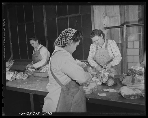 Untitled photo, possibly related to: Cincinnati, Ohio. Preparing canned pork. Girls removing fat and bones from pork