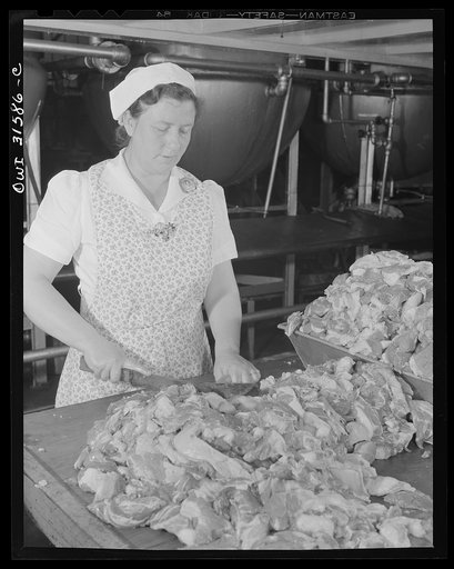 Cincinnati, Ohio. Preparing canned pork (Russian: "svinaia tushonka") for lend-lease shipment to the USSR, at the Kroger grocery and baking company. Mrs. M. Bery, trimming down pork to size before twenty percent pre-shrinkage treatment. Her husband is in defense work, and her three sons are in the U