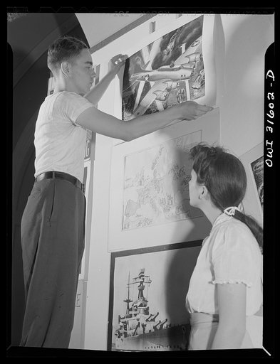 Untitled photo, possibly related to: Washington, D.C. National exhibit at the Library of Congress of paintings, photographs and posters dealing with aspects of the war, made by high school students from all over the country. A boy with one of the cut-outs
