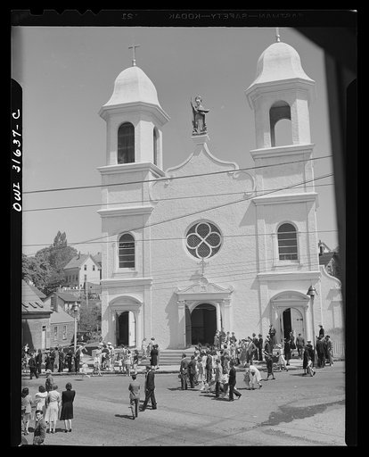 Gloucester, Massachusetts. The Portugeese church of Our Lady of Good Voyage is notes for its carillion of thirty-two bells. Above the doors is a Madonna holding a schooner in one hand while the other is raised in blessing the waves
