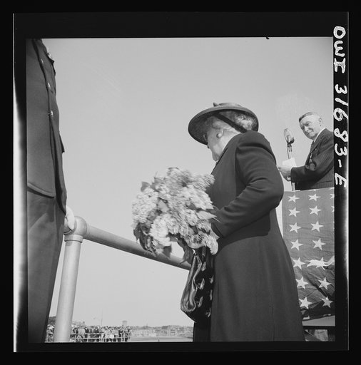 Gloucester, Massachusetts. Memorial services for a fisherman lost at sea. The fisherman's widow is tossing a bunch of flowers into the sea