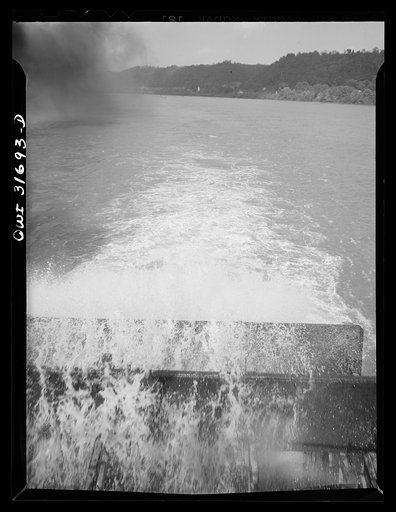 Looking over the water wheel of a towboat going down the Ohio River