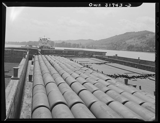Gas containers and iron pipe in barges being towed by the towboat Ernest T. Weir going down the Ohio River to Cincinnati