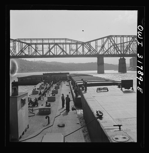 Cincinnati (vicinity), Ohio. Deckhands releasing a barge from the tow of the towboat Ernest T. Weir going down the Ohio River