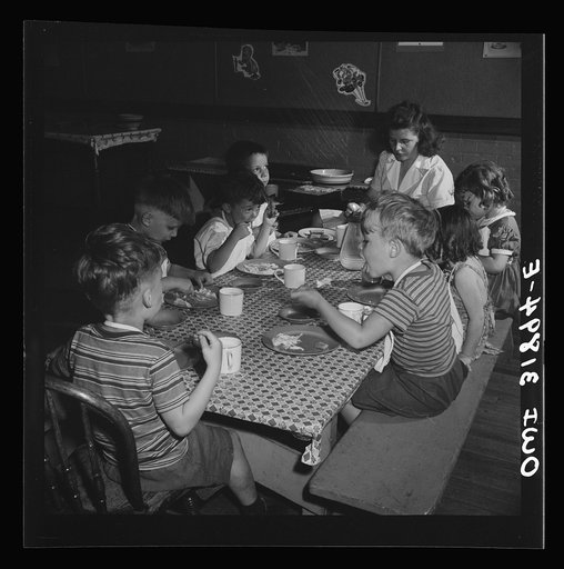 New Britain, Connecticut. A child care center, opened September 15, 1942, for thirty children, aged two to five, of mothers engaged in war industry. The hours are 6:30 a.m. to 6 p.m., six days per week. Children having lunch with a trained assistant