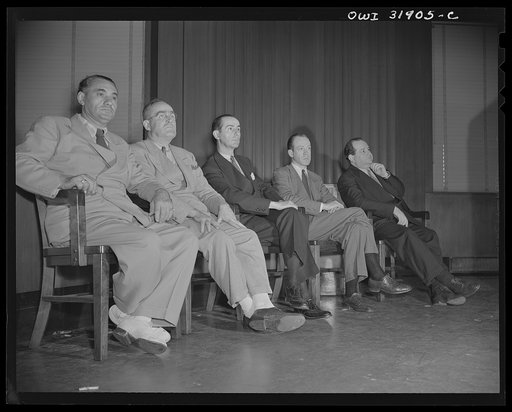 Five men seated in the courtroom(?) during a scene in "Black Marketing," a motion picture produced by the U.S. Office of War Information (OWI), and released on August 19, 1943