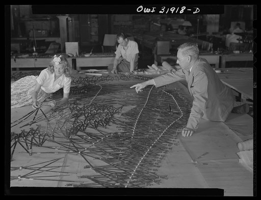 Untitled photo, possibly related to: Washington, D.C. Left to right: Mrs. Marvel Barnekov, engineering aid, Joel Langjofer, chief engineering aid, employees of the U.S. Geological survey, Alaska branch, and Dr. William Wrather, director of the Geological Survey, adjusting templates to a base map man
