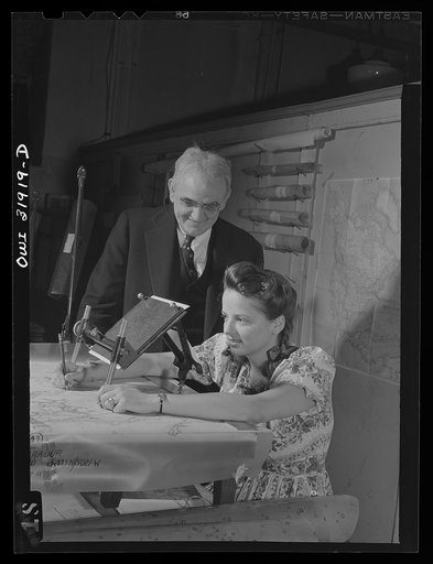 Untitled photo, possibly related to: Washington, D.C. Dr. Philip S. Smith, chief Alaskan geologist, and Miss Hallman, engineering aid, employees of the U.S. Geological survey, Alaska branch, using an oblique sketch master. The instrument transfers the planimetry from the oblique photgraph to the bas
