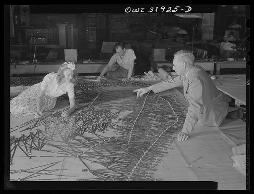 Washington, D.C. Left to right: Mrs. Marvel Barnekov, engineering aid, Joel Langjofer, chief engineering aid, employees of the U.S. Geological survey, Alaska branch, and Dr. William Wrather, director of the Geological Survey, adjusting templates to a base map manuscript