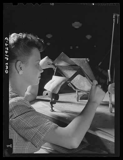 Washington, D.C. Miss Alice Blackwell, an employee of the U.S. Geological Survey, Alaska branch, is inserting an oblique aerial photograph into the oblique sketch master for the purpose of transferring the planimetry from the photograph to the base map of the manuscript