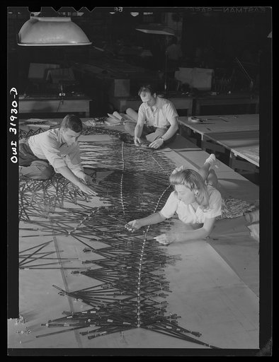 Washington, D.C. Employees of the U.S. Geological Survey, Alaska branch, adjusting the templates on the base map manuscript in the completion of an air navigation chart from aerial photographs. Left to right: William MacDonald, engineering aid, (now in the Marine Corps), Joel Langhofer, chief engine