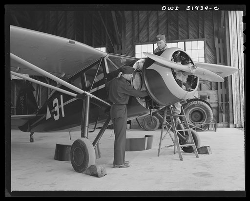 Bar Harbor, Maine. Civil Air Patrol base headquarters of coastal patrol no. 20. Chief engineering officer working with a ground crew mechanic on a routine engine overhaul