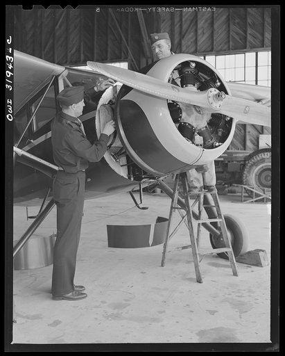 Bar Harbor, Maine. Civil Air Patrol base headquarters of coastal patrol no. 20. Chief engineering officer working with a ground crew on a routine engine overhaul