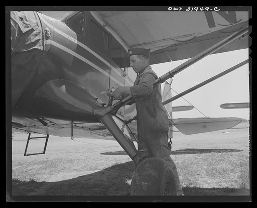 Bar Harbor, Maine. Civil Air Patrol base headquarters of coastal patrol no. 20. Member of the ground crew making adjustments on a patrol plane