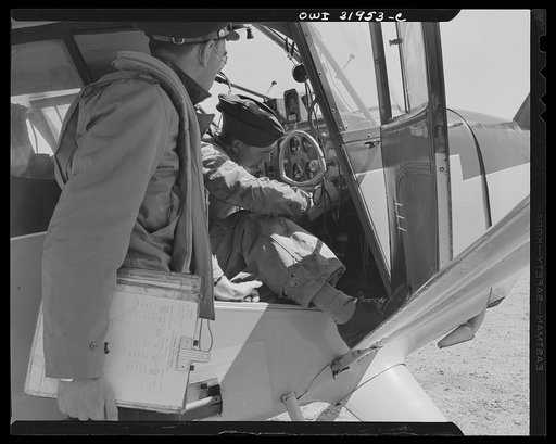 Bar Harbor, Maine. Civil Air Patrol base headquarters of coastal patrol no. 20. Ground crew making adjustments on a radio before a pilot takes the plane out on patrol