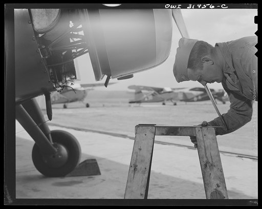 Untitled photo, possibly related to: Bar Harbor, Maine. Civil Air Patrol base headquarters of coastal patrol no. 20. Ground crew mechanic inspecting the pitch of the propeller of a patrol plane