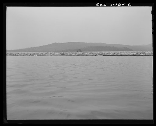 Spring pulpwood drive on the Brown Company timber holdings in Maine. To tow the full boom down Mooselookmeguntic Lake, the steamer runs ahead a quarter of a mile, casts anchor and pulls the boom up on its winches. By this process, it can make the twelve mile haul in about sixteen hours, with a fair 