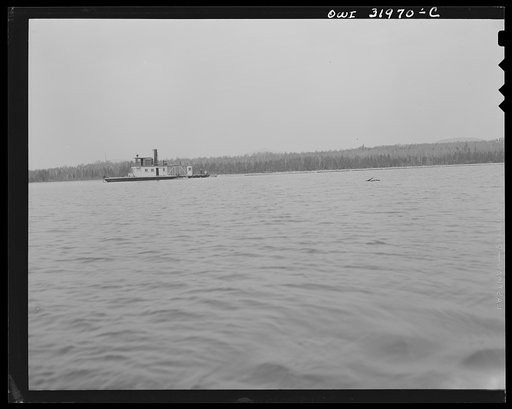 Spring pulpwood drive on the Brown Company timber holdings in Maine. Side-wheel steamer, which tows the pulp wood twelve miles down Mooselookmeguntic Lake, returns with an empty boom which will exchange for a full one