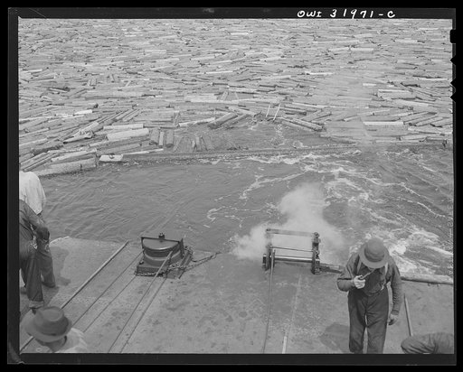 Spring pulpwood drive on the Brown Company timber holdings in Maine. Steamer getting under way after it has attached a cable to the boom it is going to tow down Mooselookmeguntic Lake