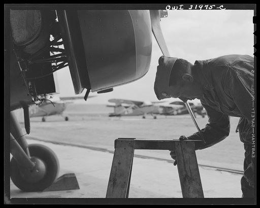 Bar Harbor, Maine. Civil Air Patrol base headquarters of coastal patrol no. 20. Ground crew mechanic inspecting the pitch of the propeller of a patrol plane