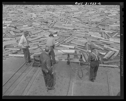 Spring pulpwood drive on the Brown Company timber holdings in Maine. Picking up the boom and attaching cable from the steamer to a link in the boom-chain which surrounds the pulpwood to be towed down Mooselookmeguntic Lake