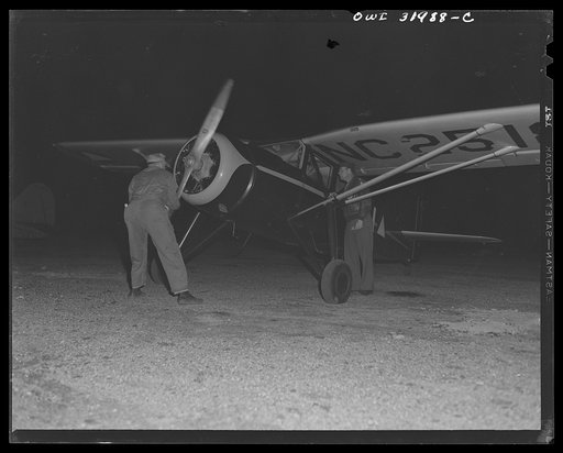 Bar Harbor, Maine. Civil Air Patrol base headquarters of coastal patrol no. 20. Ground crew winding up an engine before taking on dawn patrol