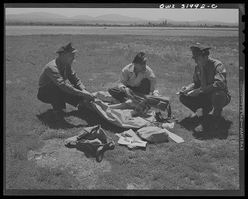 Bar Harbor, Maine. Civil Air Patrol base headquarters of coastal patrol no. 20. Intelligence officer checking safety equipment issued to the pilot and observer of a patrol plane, including rubber boat and life jacket "Mae West," inflatable by carbon dioxide gas cartridges; repair kit to mend bullet 