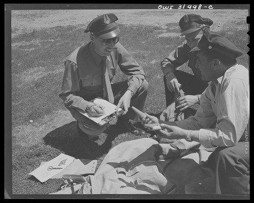 Bar Harbor, Maine. Civil Air Patrol base headquarters of coastal patrol no. 20. Pilot checking his safety equipment with an intelligence officer. The object in his hand is a plug to screw into bullet holes in the rubber boat