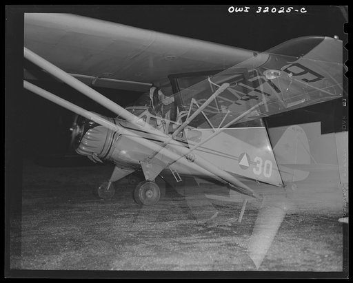 Untitled photo, possibly related to: Bar Harbor, Maine. Civil Air Patrol base headquarters of coastal patrol no. 20. Ground crew plugging in an auxiliary battery to start a plane on dawn patrol