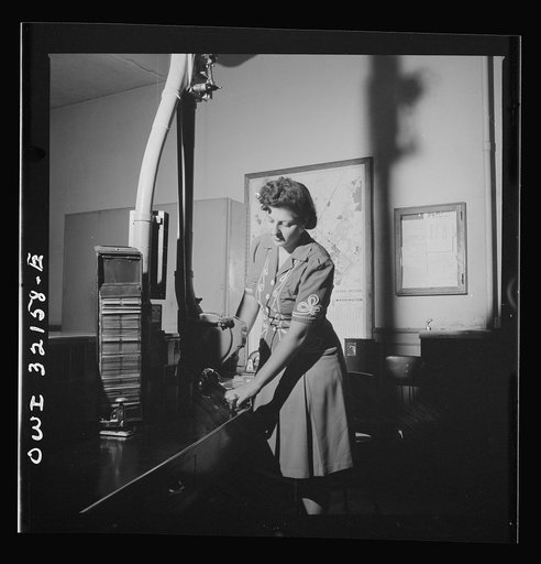 Washington, D.C. Eleanor Ernest taking a cylinder with telegrams from the pneumatic tube in which they have been sent across several blocks by air pressure