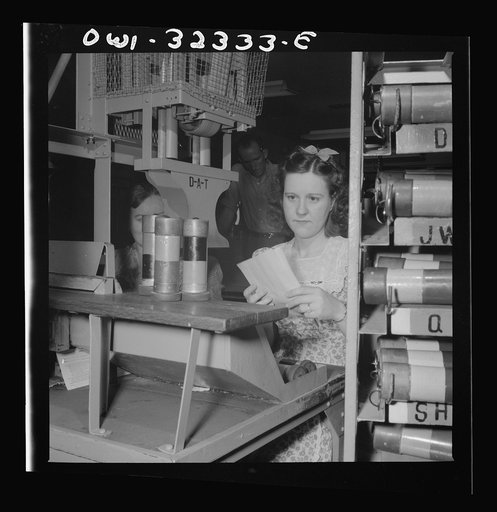 Washington, D.C. Mrs. Eva Poovey working with pneumatic tubes from which telegrams are taken at the Western Union telegraph office