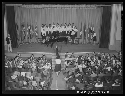 Untitled photo, possibly related to: Oswego, New York. Howard Fast, author of Citizen Tom Paine, addressing the high school. United Nations flags are on the stage during United Nations week