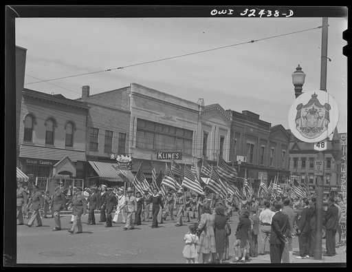 Oswego, New York. United Nations heroes marching in the Flag Day parade on Bridge Street, decorated with United Nations seals (left)