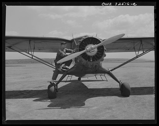 Bar Harbor, Maine. Civil Air Patrol base headquarters of coastal patrol no. 20. Ground crew mechanic making adjustments on a plane before it takes off